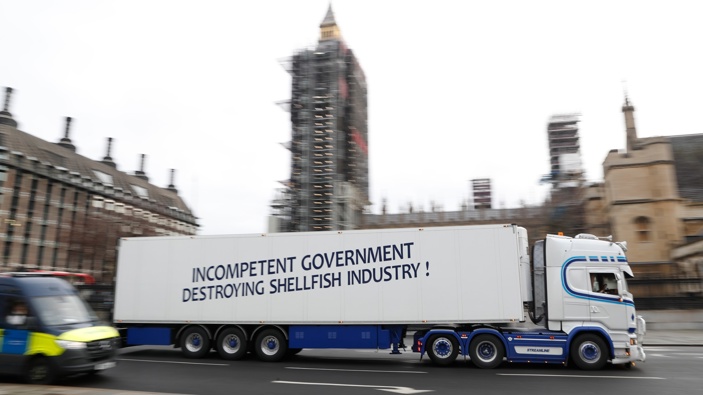 A shellfish export truck with a protest sign written across the trailer 'Incompetent Government Destroying Shellfish Industry" drives past the Palace of Westminster in London during a demonstration by British Shellfish exporters to protest Brexit-related red tape they claim is suffocating their business. (Photo / AP)