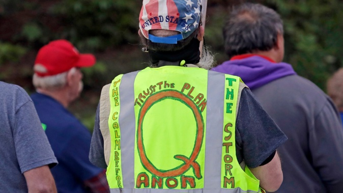 n this May 14, 2020, file photo, a person wears a vest supporting QAnon at a protest rally in Olympia, Washington. (Photo / AP)