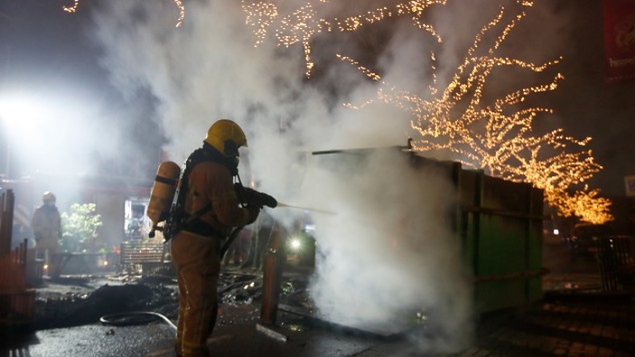 A firefighter extinguishes a container that was set alight during protests against a nation-wide curfew in Rotterdam, Netherlands. (Photo / AP)
