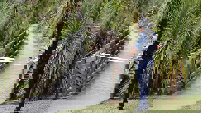 A police officer at a walkway cordon where a man was found in the water at Meola Creek, Westmere, this morning. Photo / Dean Purcell