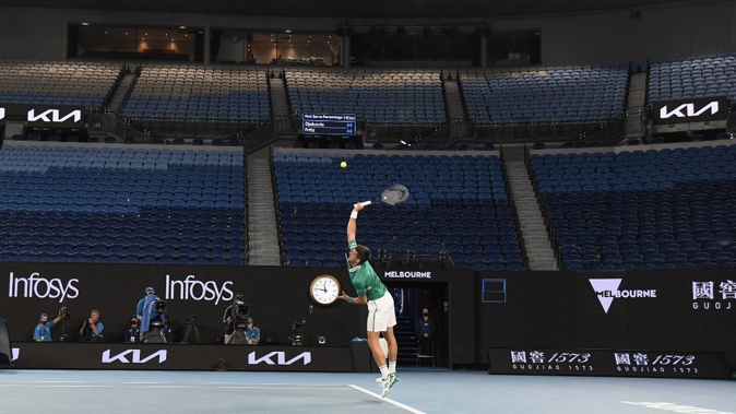 Novak Djokovic serves in front of a near-empty Rod Laver Arena during last night's Australian Open. Photo / AP