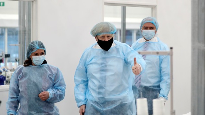 Britain's Prime Minister Boris Johnson, wearing a face mask to prevent the spread of the coronavirus, visits a PPE manufacturing facility during a visit to the north east of England. (Photo / AP)