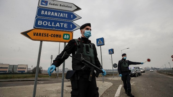 Carabinieri officers patrol one of the main access road to Bollate, in the outskirts of Milan, Italy. (Photo / AP)