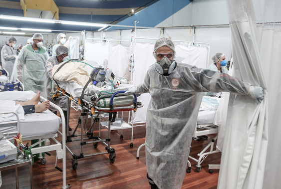 Medical staff members transport a patient on a stretcher at the Pedro DellAntonia Sports Complex field hospital as coronavirus cases soar on March 11, in Santo Andre, Brazil.