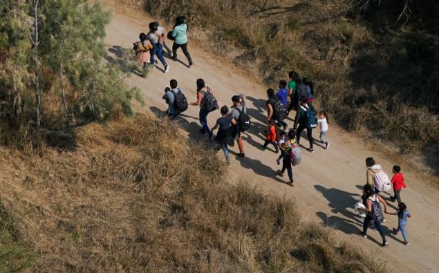 Migrants walk on a dirt road after crossing the U.S.-Mexico border, Tuesday, March 23, 2021, adnist a surge of migrants on the Southwest border has the Biden administration on the defensive. (Photo / AP)