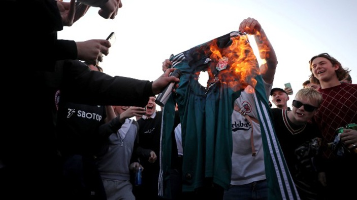 Fans burn a Liverpool replica shirt outside Elland Road, as a protest against Liverpool's decision to be included amongst the clubs attempting to form a new European Super League. (Photo / AP)