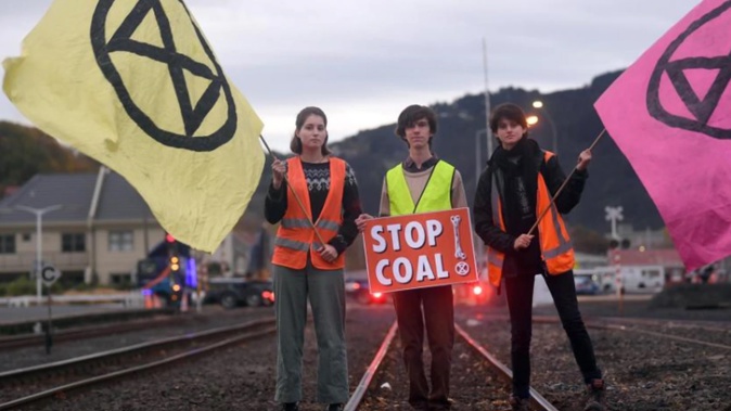 Protesters opposing the use and transport of coal block the railway tracks near the Dunedin Railway Station this morning. Photo / Stephen Jaquiery