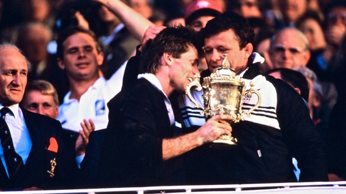 David Kirk with injured captain Andy Dalton and the Webb Ellis cup after the All Blacks won the 1987 Rugby World Cup final against France. (Photo / Photosport)