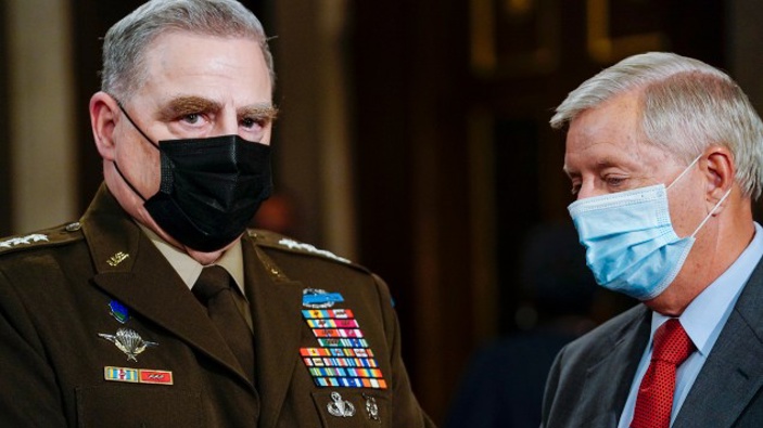 Joint Chiefs Chairman Gen. Mark Milley, left, and Sen. Lindsey Graham, R-S.C., talk as they arrive the chamber ahead of President Joe Biden speaking to a joint session of Congress