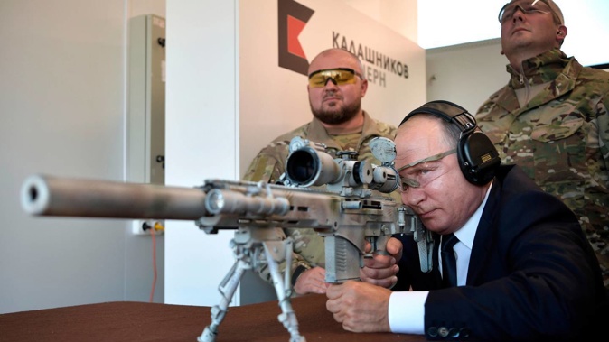 Russian President Vladimir Putin aims a Kalashnikov SVCh-308 sniper rifle prototype during a visit to the Patriot military exhibition centre. (Photo / AP)