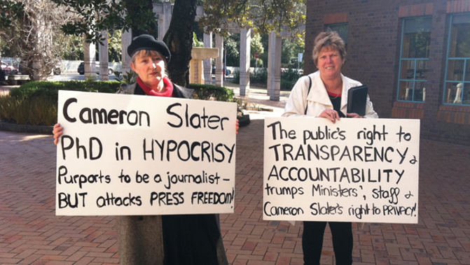 Two protestors outside the Cameron Slater's interim injunction hearing (Corazon Miller)