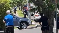 A police officer points his gun towards a medical centre in Nowra. Photo / Twitter