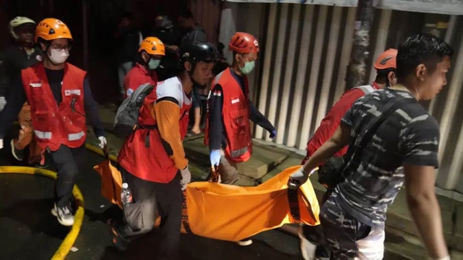 Rescuers carry the body of a victim of a fire in Jakarta, Indonesia. Photo / AP