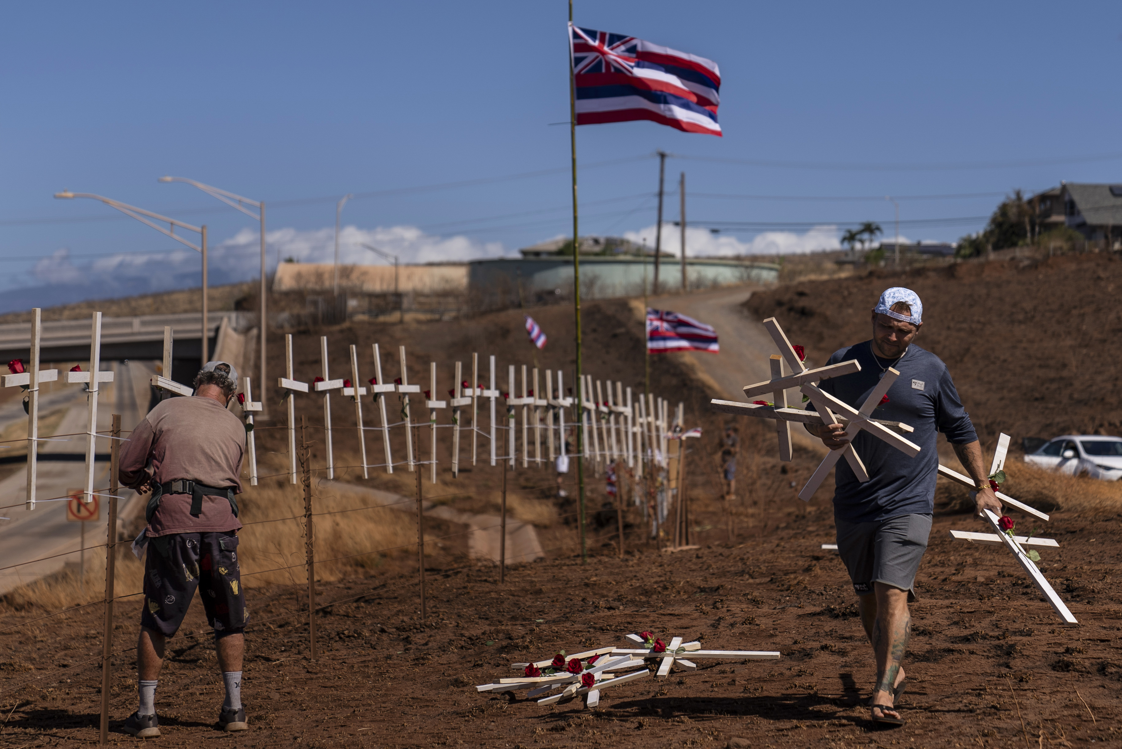 Ethan Meyers, right, carries crosses to put up to honor the victims killed in a wildfire in Lahaina, Hawaii, Aug. 22, 2023. Photo / AP