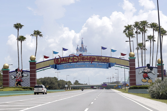 Cars drive under a sign greeting visitors near the entrance to Walt Disney World. Photo / AP