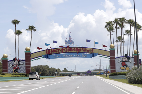 Cars drive under a sign greeting visitors near the entrance to Walt Disney World. Photo / AP