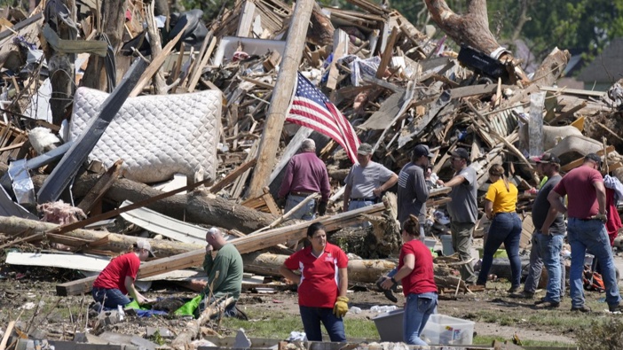 Local residents clean up debris from a tornado damaged home, Wednesday, May 22, 2024, in Greenfield, Iowa. (AP Photo/Charlie Neibergall)