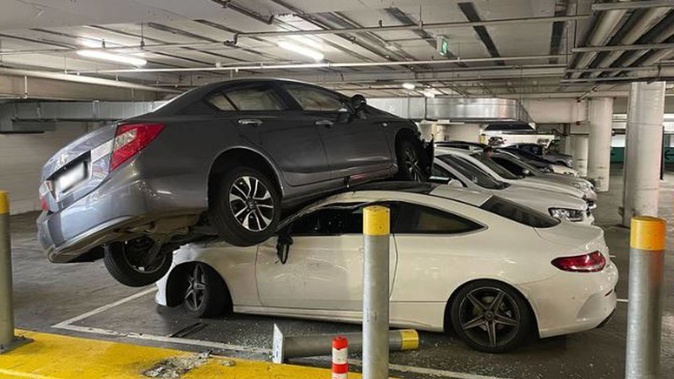 A Mercedes owner's carpark mishap has blown up online after footage of their luxury sedan perched atop another car made waves on TikTok. Photo / 9 News