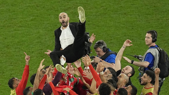 Morocco's head coach Walid Regragui is thrown in the air at the end of the World Cup round of 16 match. Photo / AP