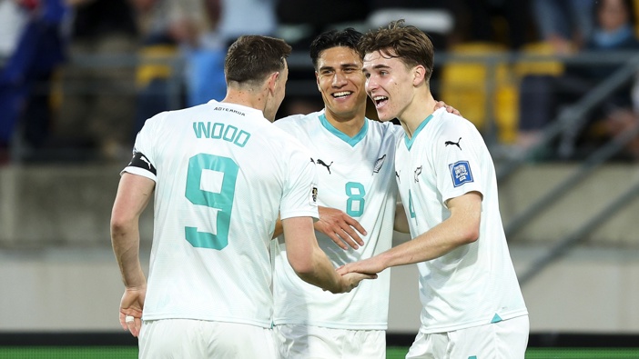 Tyler Bindon (R) of New Zealand celebrates with Chris Wood and Marko Stamenić after scoring a goal during the FIFA World Cup 2026 OFC Qualifier Semi Final match between New Zealand All Whites and Fiji at Sky Stadium on March 21, 2025 in Wellington, New Zealand. (Photo by Hagen Hopkins/Getty Images)
