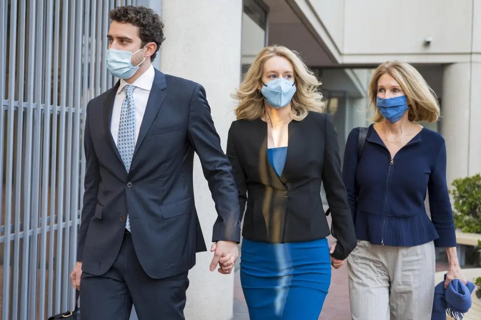 Elizabeth Holmes, center, walks into federal court in San Jose, Calif., Monday, Nov. 22, 2021. Holmes is accused of duping elite financial backers, customers and patients into believing that her startup was about to revolutionize medicine. (AP Photo/Nic Coury)
