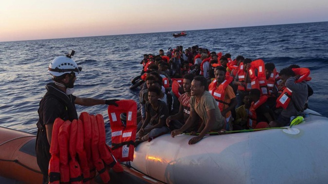 Crew of the Sea-Watch 3 distribute life jackets to 108 people in a boat in distress in the central Mediterranean. Photo / AP