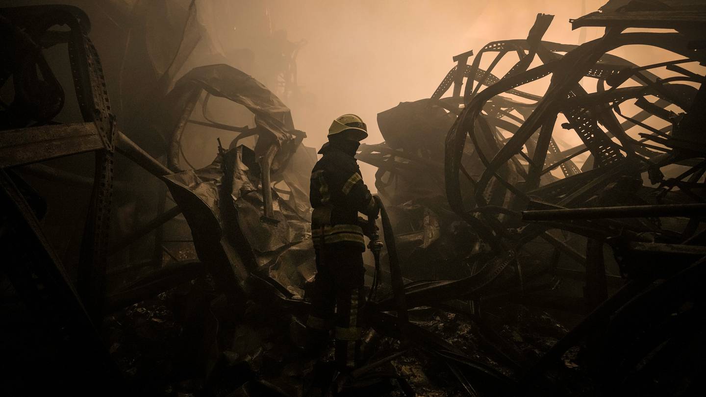 A Ukrainian firefighter drags a hose inside a large food products storage facility which was destroyed by an airstrike in the early morning hours on the outskirts of Kyiv. (Photo / AP)