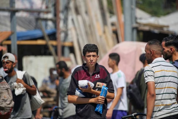 Displaced Palestinians at the Nuseirat refugee camp haul food parcels and other items they managed to get from a GHF aid distribution point at the so-called "Netzarim corridor" in the central Gaza Strip. Photo / Eyad Baba, AFP