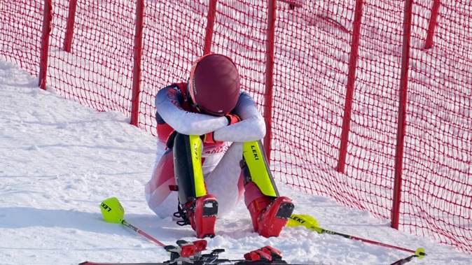A dejected Mikaela Shiffrin sits on the side of the course after skiing out in the first run of the women's slalom at the 2022 Winter Olympics. Photo / AP