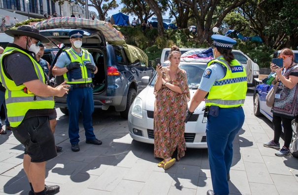 Wellington City Council parking wardens, with police escorts, issuing tickets to a protester's vehicle parked around Parliament on the eighth day of the occupation. (Photo / Mark Mitchell)