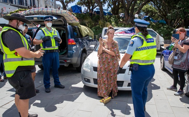 Wellington City Council parking wardens, with police escorts, issuing tickets to a protester's vehicle parked around Parliament on the eighth day of the occupation. (Photo / Mark Mitchell)
