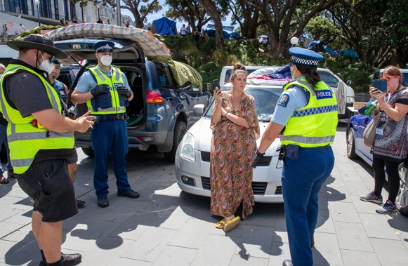 Wellington City Council parking wardens, with police escorts, issuing tickets to a protester's vehicle parked around Parliament on the eighth day of the occupation. (Photo / Mark Mitchell)