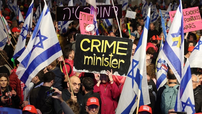 Demonstrators lift placards and national flags during an anti-government protest in front of the Israeli Defence Ministry in Tel Aviv on January 11. Photo / AFP
