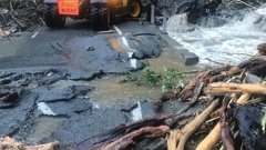 A washout on State Highway 6 after a rain-swollen stream spewed debris across the road.