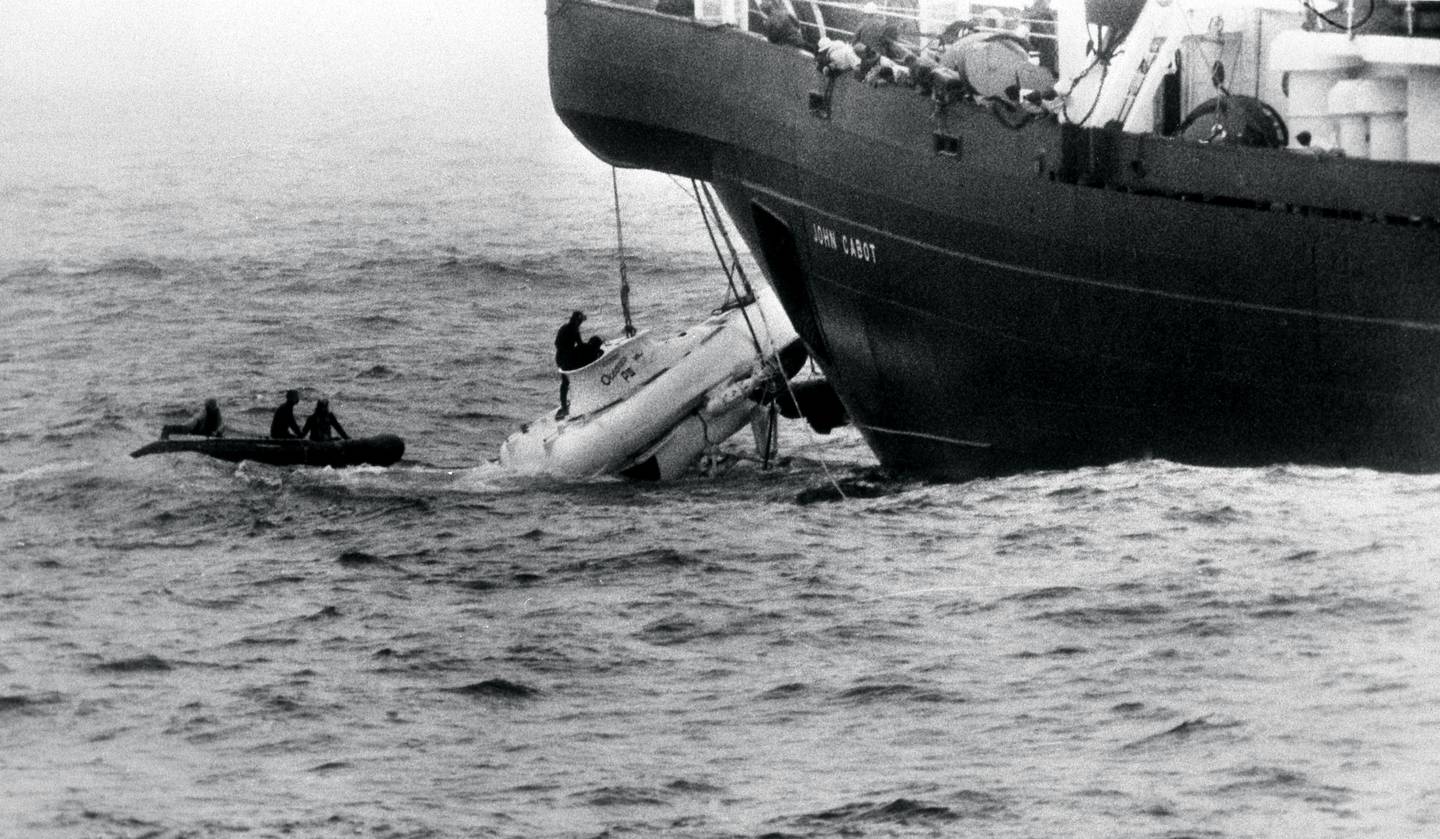 Divers begin to open the hatch of the miniature submarine Pisces III as she breaks water under the John Cabot after being hauled from the Atlantic seabed off Cork. Photo / Getty Images