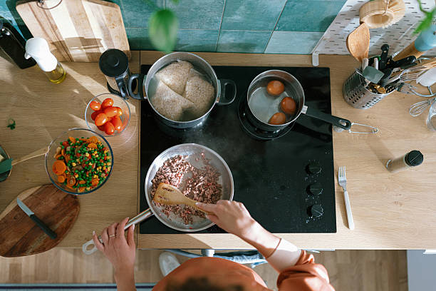 Top view of hands frying ground meat in a pan - stock photo