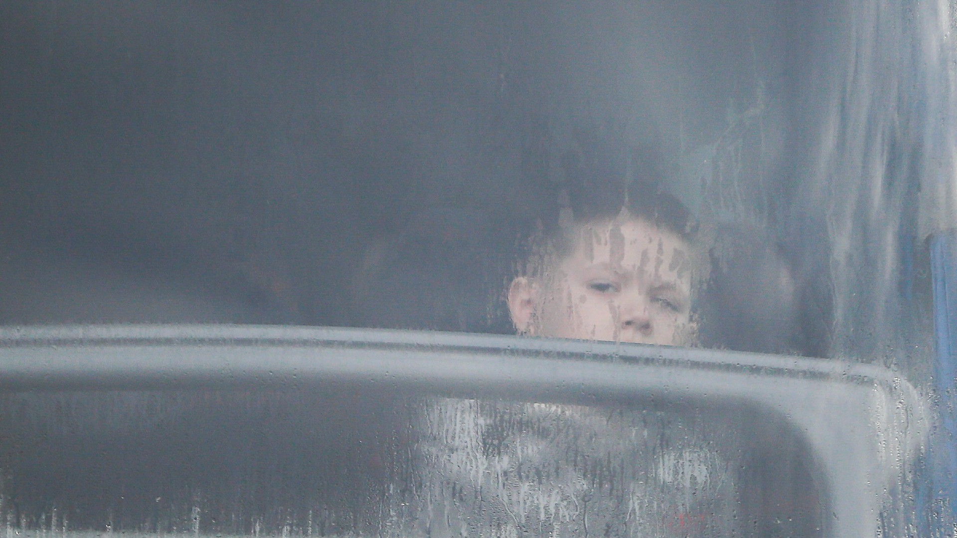 A child looks out of the window of a bus full of refugees fleeing the conflict in Ukraine, at the Medyka border crossing, in Poland, Sunday, Feb. 27, 2022. (Photo / AP)