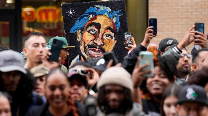 An image of the late rapper and actor Tupac Shakur appears among fans during a ceremony honouring Shakur with a star on the Hollywood Walk of Fame. Photo / AP