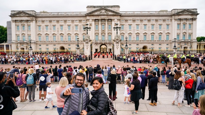 Members of the public watch the Changing of the Guard ceremony at Buckingham Palace, which is taking place for the first time since the start of the coronavirus pandemic. (Photo / AP)
