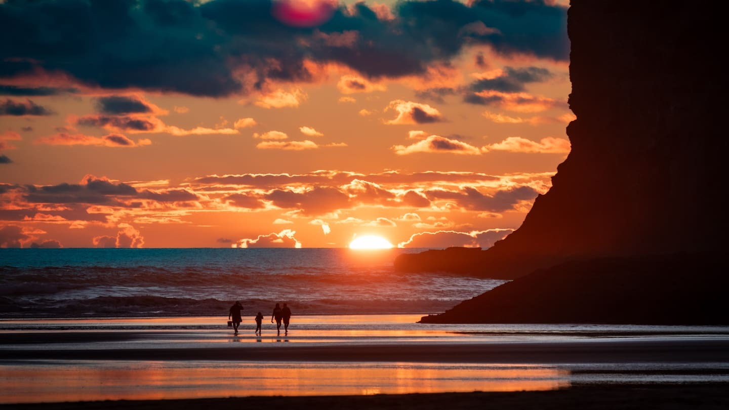 Three swimmers rescued from rip at Bethells Beach after sunset