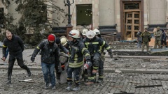 Ukrainian emergency service personnel carry the body of a victim out of the damaged City Hall building following shelling in Kharkiv. (Photo / Pavel Dorogoy, AP)