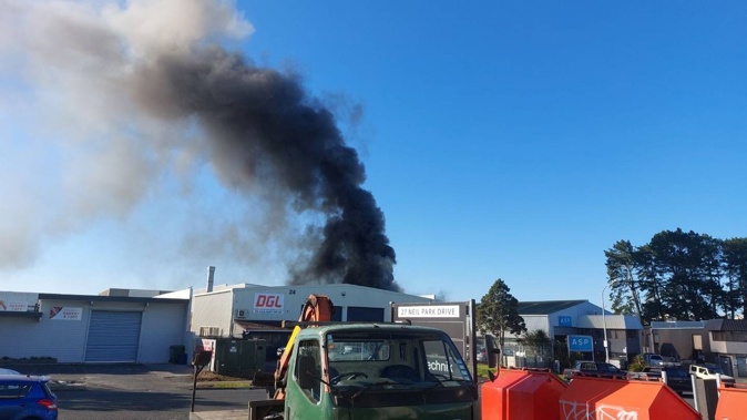 Black smoke billowing from the fire on Neilpark Dr in Auckland. Photo / Kerry Watt
