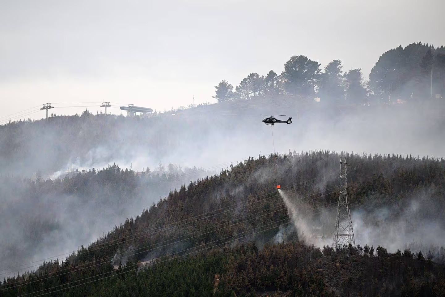 Helicopters work to extinguish the large fire that is burning in Christchurch's Port Hills causing mass evacuations. New Zealand Herald Photograph by Joe Allison