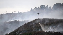 Helicopters work to extinguish the large fire that is burning in Christchurch's Port Hills causing mass evacuations. New Zealand Herald Photograph by Joe Allison