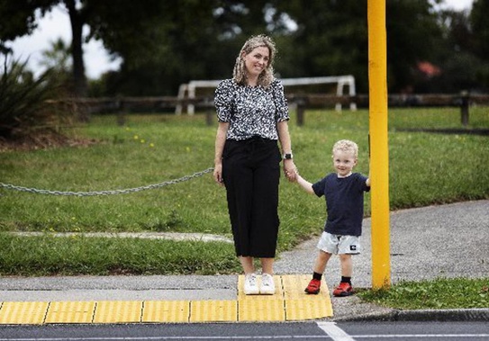 Hayley Hamilton and son, Bodie, at the light-controlled pedestrian crossing where he was struck by a car in January. (Photo / Mike Scott)