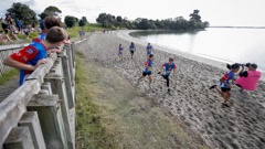 Kids run along the beach at Pt England Reserve as the Weetbix TRYathlon is reduced to a duathlon after the swimming section was cancelled due to poor water quality. Photo / Alex Burton