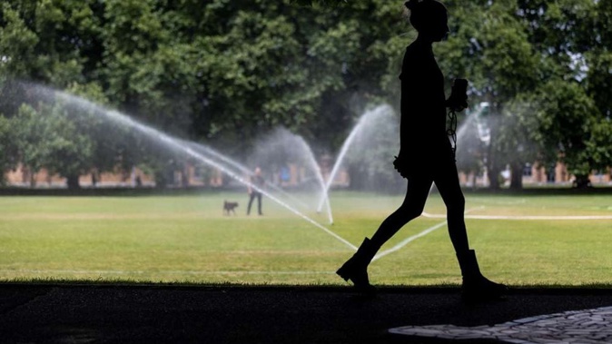 Lunchtime exercise and sprinklers during summer time in Auckland's Victoria park. Photo / Michael Craig