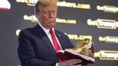 Donald Trump holds gold Trump sneakers at Sneaker Con Philadelphia, an event popular among sneaker collectors. Photo / AP