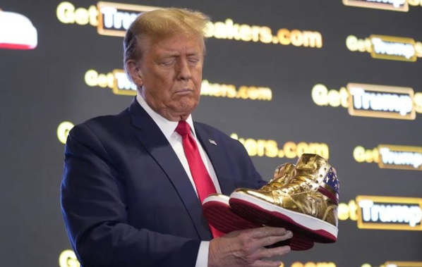 Donald Trump holds gold Trump sneakers at Sneaker Con Philadelphia, an event popular among sneaker collectors. Photo / AP