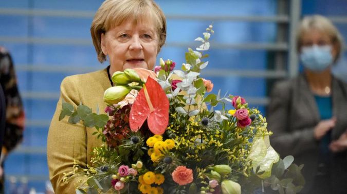 German Chancellor Angela Merkel holds a bouquet from Vice Chancellor and Finance Minister Olaf, Scholz prior to the cabinet meeting at the chancellery in Berlin, Germany. (Photo / AP)